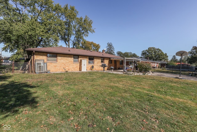 rear view of property with a patio and a lawn