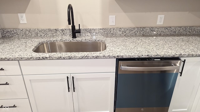 kitchen with sink, stainless steel dishwasher, white cabinets, and light stone countertops