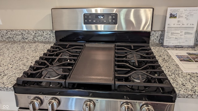 room details featuring light stone countertops and stainless steel range with gas stovetop