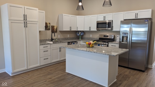 kitchen with stainless steel appliances, a center island, sink, and white cabinets