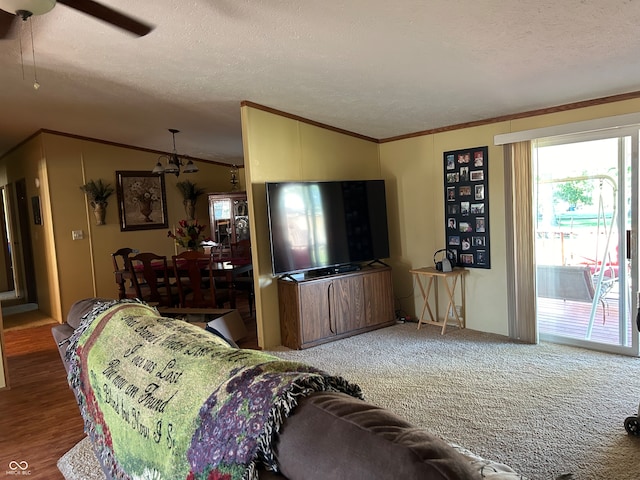 living room with crown molding, ceiling fan, wood-type flooring, and a textured ceiling