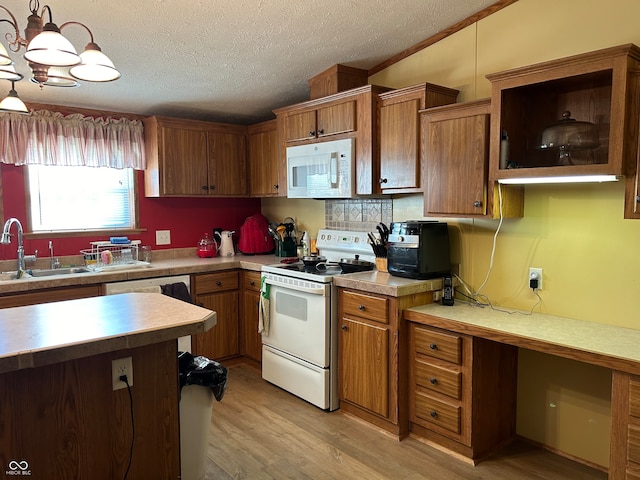 kitchen with sink, pendant lighting, a textured ceiling, white appliances, and light wood-type flooring