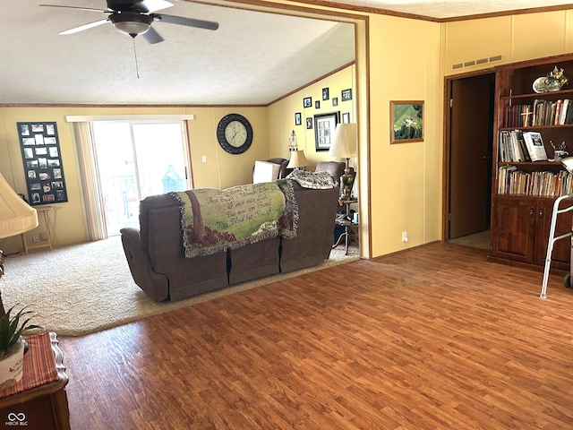 living room featuring a textured ceiling, ceiling fan, crown molding, hardwood / wood-style flooring, and lofted ceiling