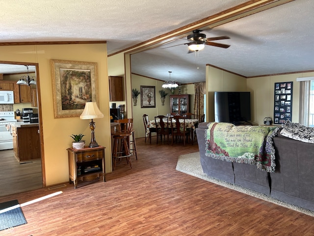 living room featuring hardwood / wood-style flooring, ceiling fan, vaulted ceiling with beams, and a textured ceiling