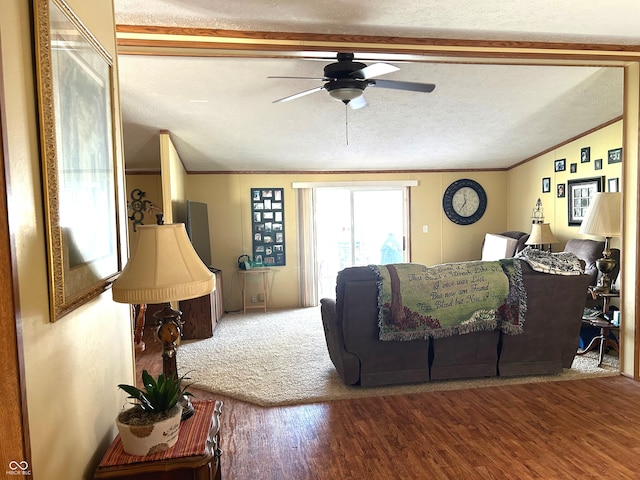 living room with a textured ceiling, vaulted ceiling, ceiling fan, crown molding, and hardwood / wood-style flooring