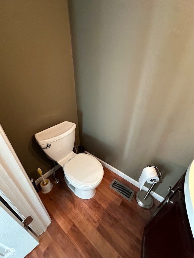 bathroom with toilet and wood-type flooring