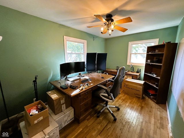 home office featuring a wealth of natural light, hardwood / wood-style floors, and ceiling fan