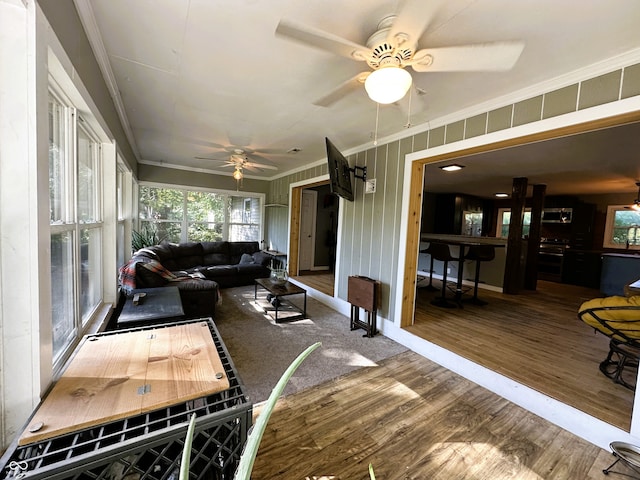 living room featuring crown molding, hardwood / wood-style floors, and ceiling fan