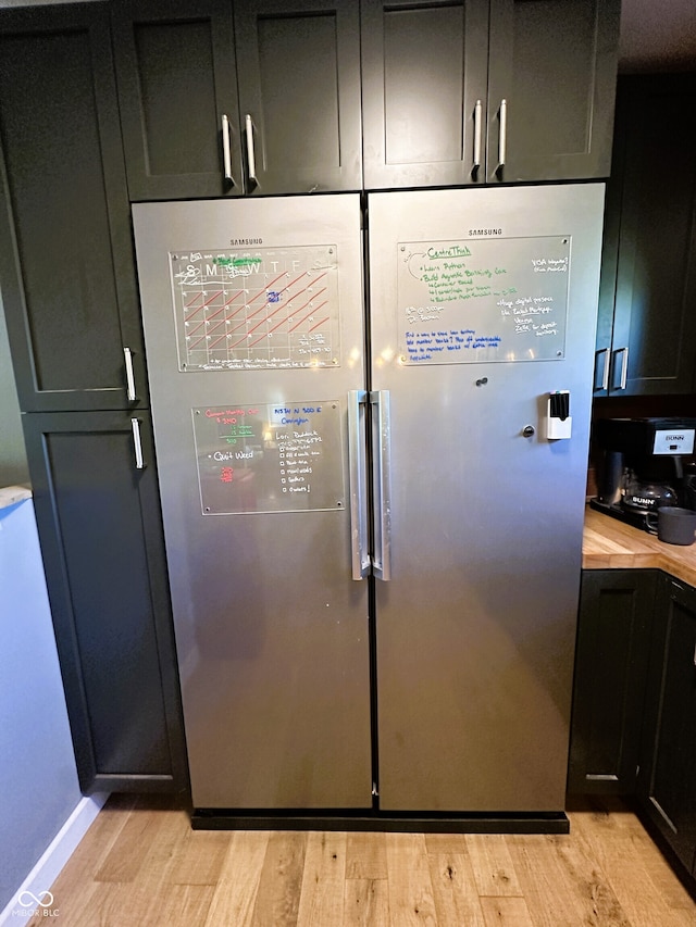 interior details with stainless steel fridge and light wood-type flooring