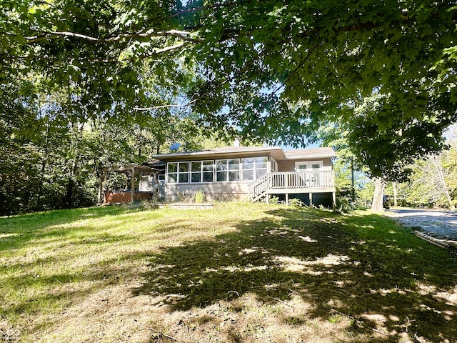 rear view of property featuring a sunroom and a lawn