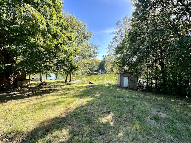 view of yard with a shed and a water view