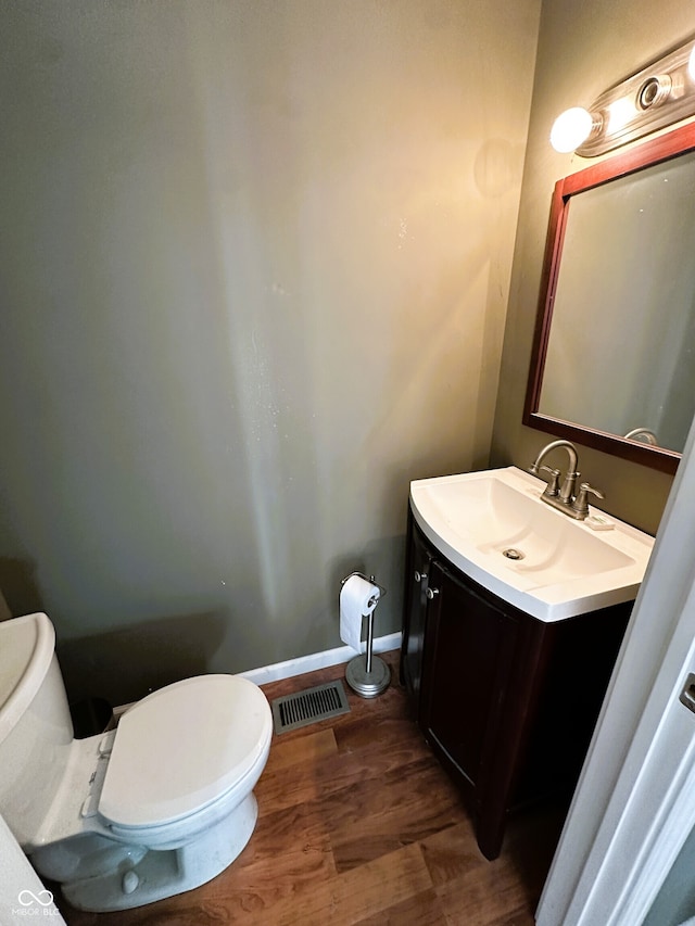 bathroom with vanity, wood-type flooring, and toilet