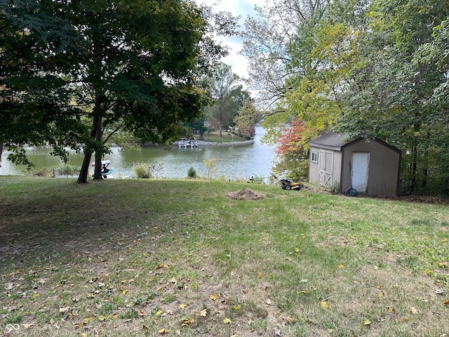 view of yard featuring a water view and a storage unit