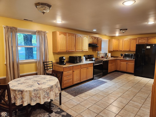 kitchen with sink, light tile patterned floors, and black appliances