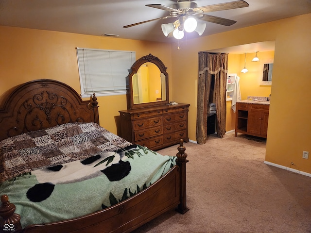 carpeted bedroom featuring ceiling fan and ensuite bath