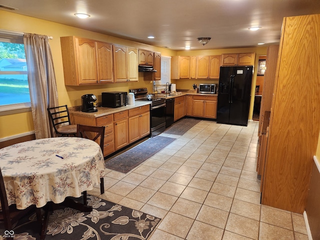 kitchen with black appliances and light tile patterned floors