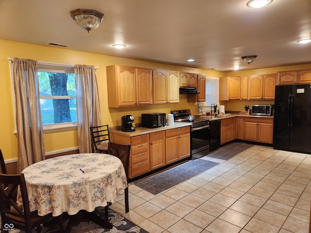 kitchen featuring light tile patterned flooring and black appliances