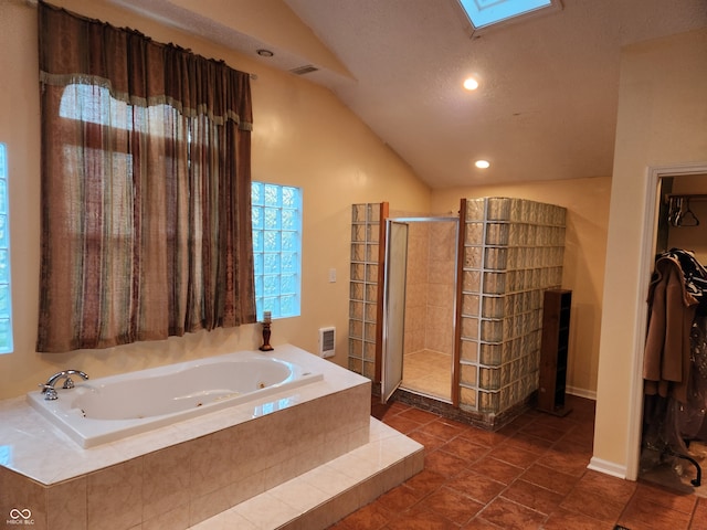 bathroom featuring vaulted ceiling with skylight, tile patterned flooring, a textured ceiling, and separate shower and tub