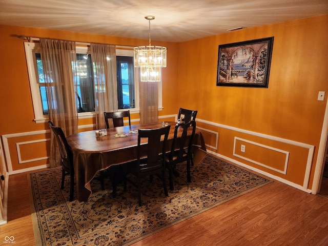 dining area with a chandelier, plenty of natural light, and hardwood / wood-style floors