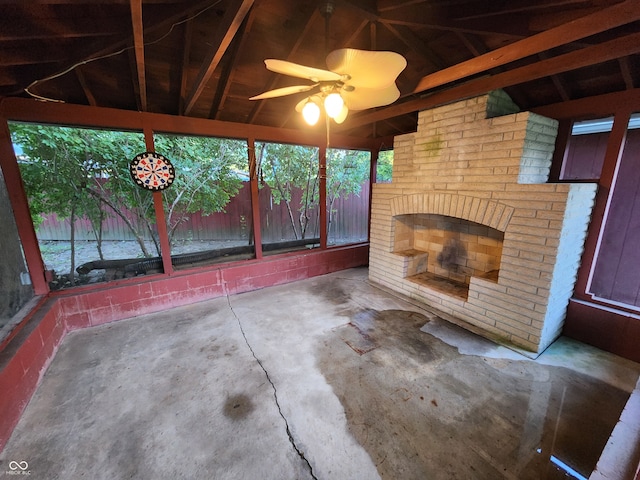 unfurnished sunroom featuring vaulted ceiling, ceiling fan, and a fireplace