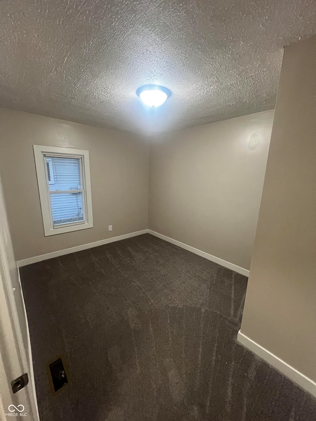 carpeted spare room with a textured ceiling