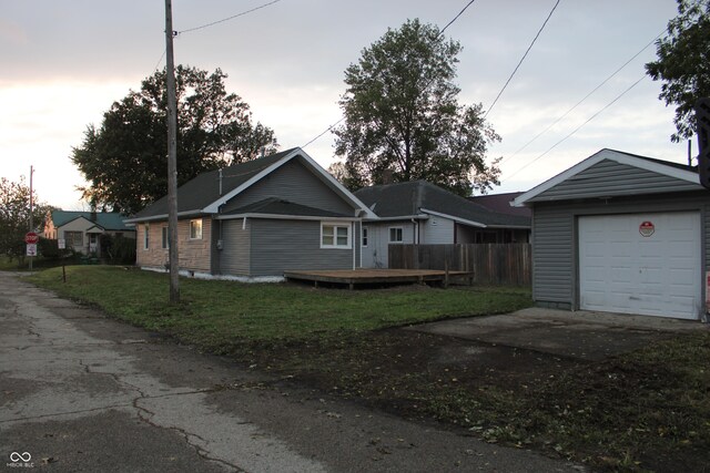 single story home with a garage and a lawn