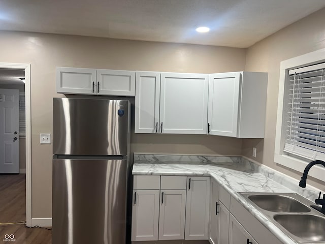 kitchen featuring white cabinets, dark hardwood / wood-style flooring, sink, and stainless steel refrigerator