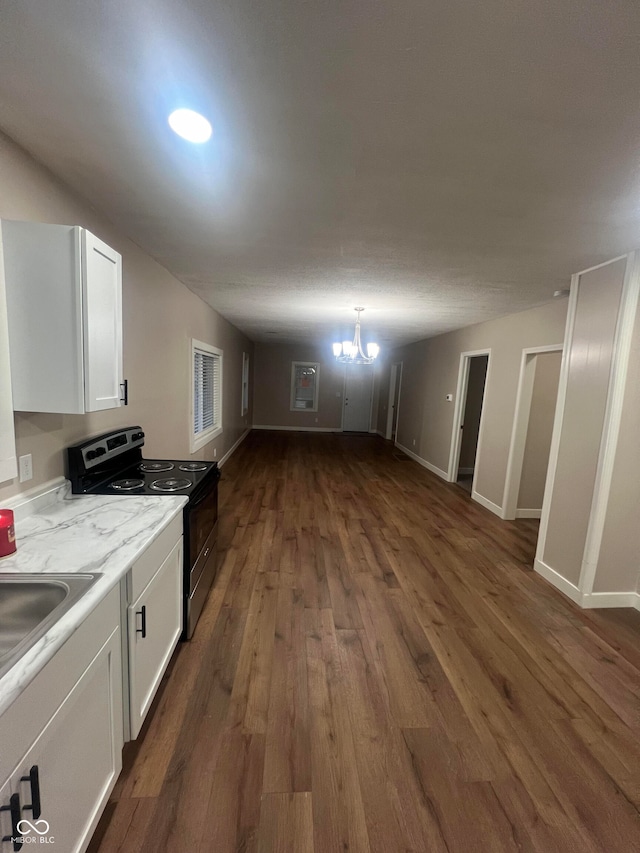 kitchen featuring white cabinetry, stainless steel electric range oven, dark hardwood / wood-style floors, and a notable chandelier