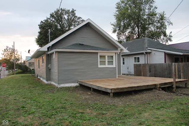 rear view of house featuring a deck and a yard