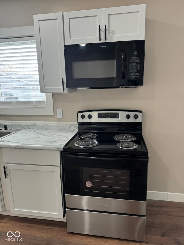 kitchen featuring dark hardwood / wood-style floors, stainless steel electric range, and white cabinetry