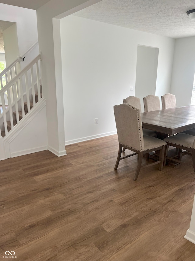 dining area featuring a textured ceiling and dark hardwood / wood-style floors