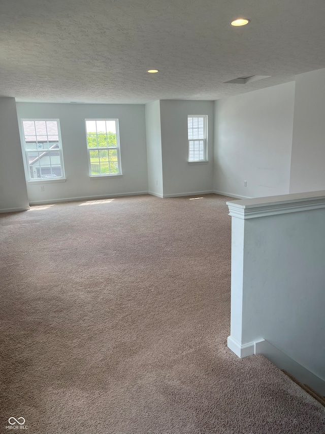 carpeted spare room featuring a textured ceiling