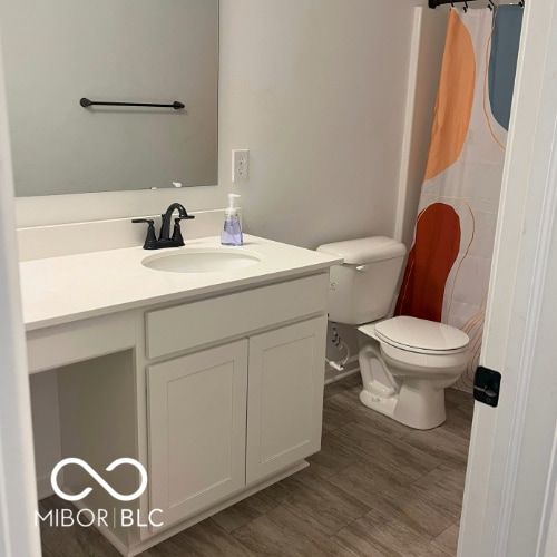 bathroom with a shower with shower curtain, wood-type flooring, vanity, and toilet