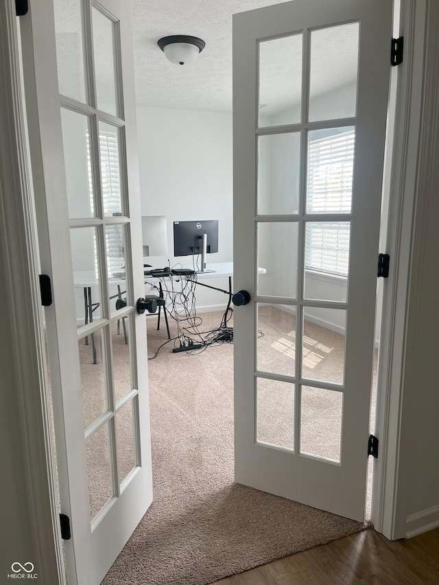 office with french doors, hardwood / wood-style flooring, and a textured ceiling