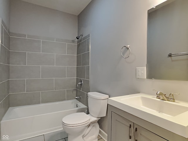 full bathroom featuring tiled shower / bath, tile patterned floors, vanity, and toilet