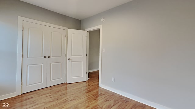 unfurnished bedroom with a closet and light hardwood / wood-style floors