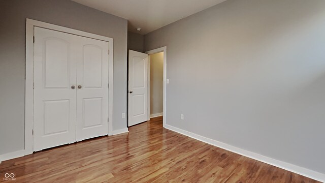 unfurnished bedroom featuring a closet and light wood-type flooring