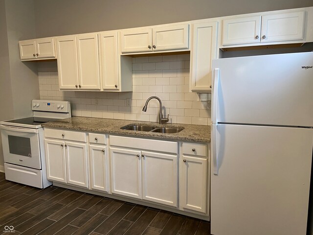 kitchen with white appliances, sink, light stone counters, dark hardwood / wood-style floors, and white cabinets