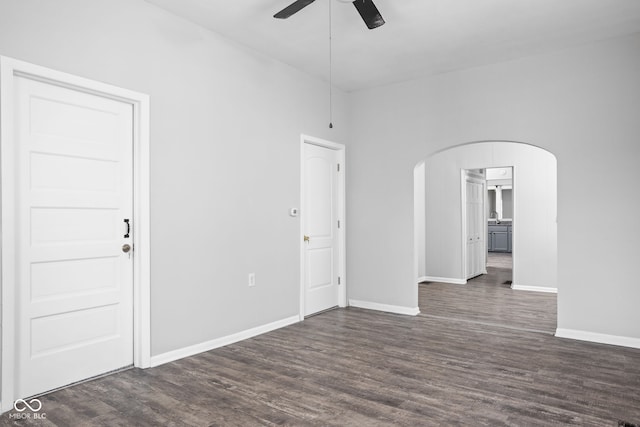 empty room with ceiling fan and dark wood-type flooring