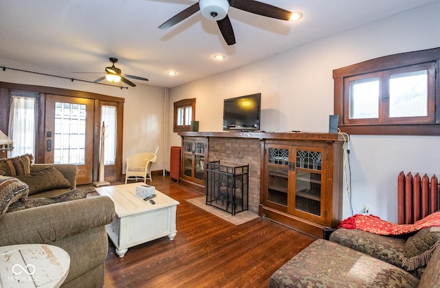 living room featuring ceiling fan, dark wood-style flooring, radiator, and plenty of natural light