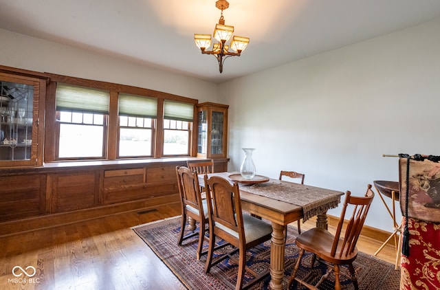 dining area with hardwood / wood-style flooring and a chandelier