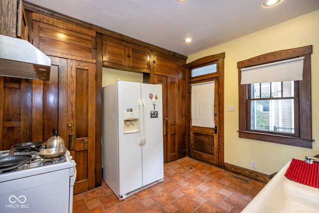 kitchen featuring white appliances, custom range hood, baseboards, visible vents, and recessed lighting