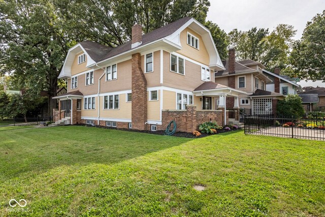 1457 Fairfield Ave, Indianapolis, IN 46205 - back of house with a chimney, fence, and a lawn