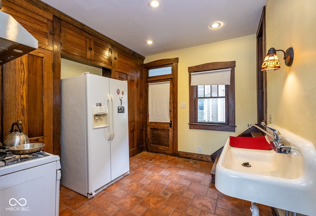 kitchen featuring extractor fan, sink, and white appliances