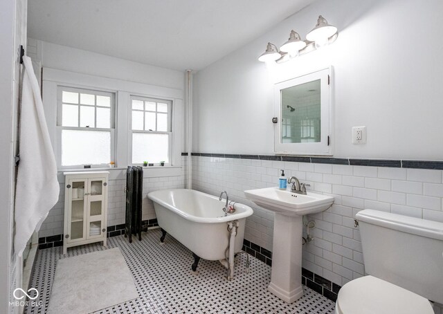 1457 Fairfield Ave, Indianapolis, IN 46205 - full bathroom with toilet, a sink, tile walls, wainscoting, and a freestanding tub