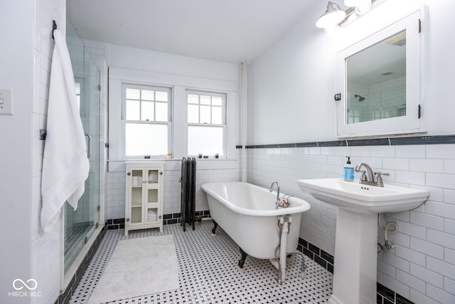 bathroom featuring tile walls, independent shower and bath, and sink