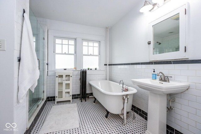 1457 Fairfield Ave, Indianapolis, IN 46205 - full bathroom with a soaking tub, a sink, tile walls, wainscoting, and a shower stall