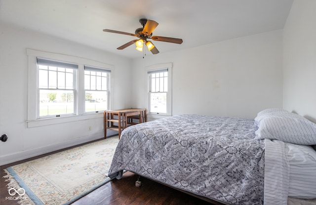 bedroom with multiple windows, hardwood / wood-style floors, and ceiling fan