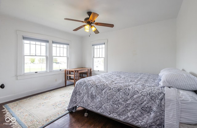 bedroom featuring baseboards, wood finished floors, and ceiling fan