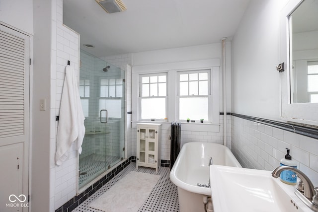 bathroom featuring tile walls, sink, and separate shower and tub